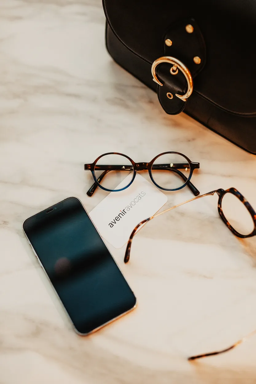 lunettes, portable et carte avenir avocats posés sur une table